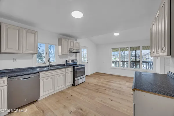 a view of wooden floor and a kitchen