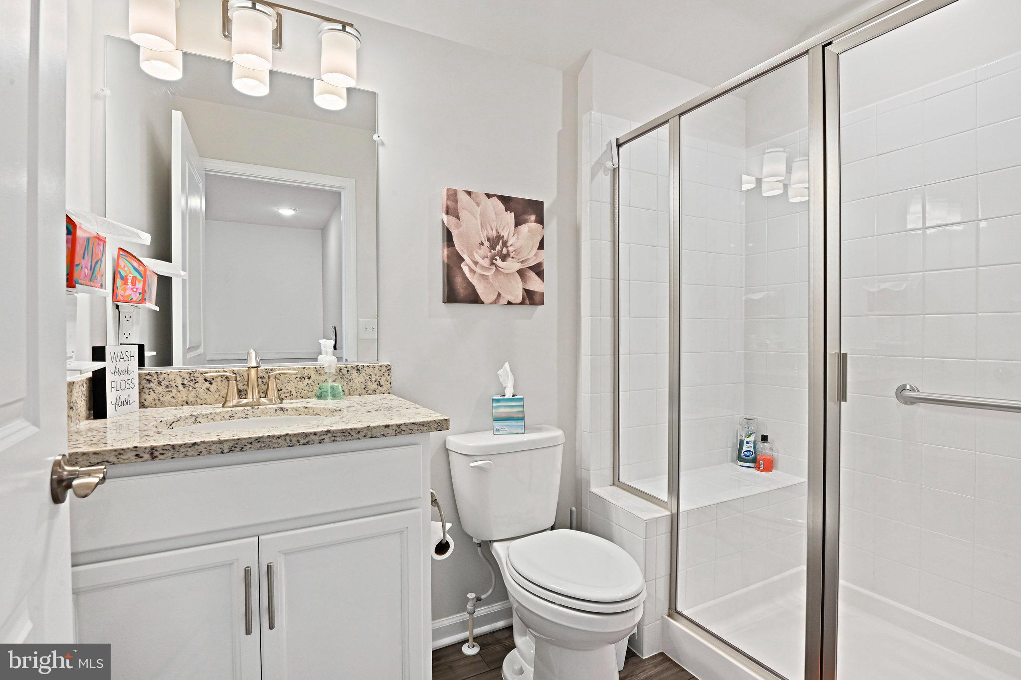 15788 Gardenia Rdg Way Haymarket, VA 20169 - Photo 26 of 50 a bathroom with a granite countertop sink a toilet and a shower