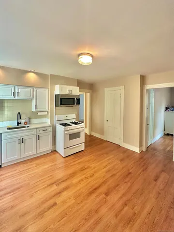 a kitchen with granite countertop a stove top oven and cabinets