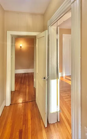 a view of a room with wooden floor and a bathroom