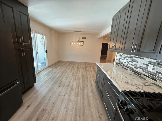a kitchen with granite countertop stainless steel appliances and refrigerator