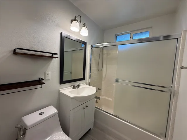 a bathroom with a granite countertop sink mirror vanity and toilet