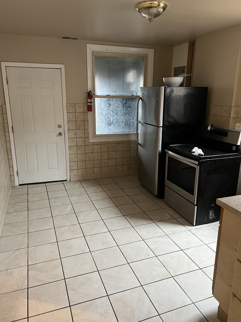 Undisclosed Address Chicago, IL 60624 - Photo 12 of 16 a kitchen with a refrigerator a oven