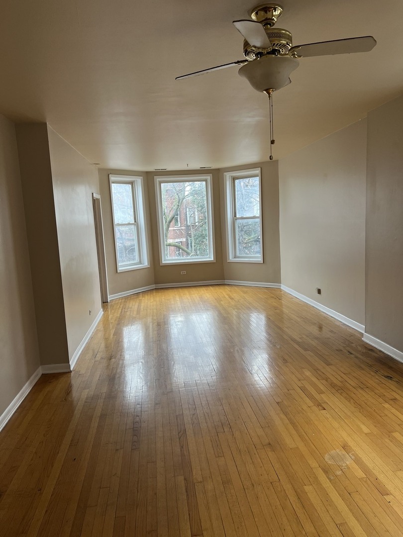 Undisclosed Address Chicago, IL 60624 - Photo 2 of 16 an empty room with wooden floor and windows