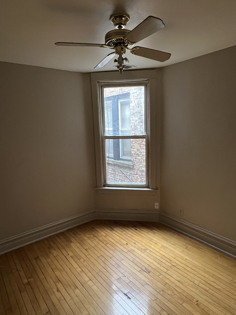 Undisclosed Address Chicago, IL 60624 - Photo 5 of 16 wooden floor in an empty room with a window