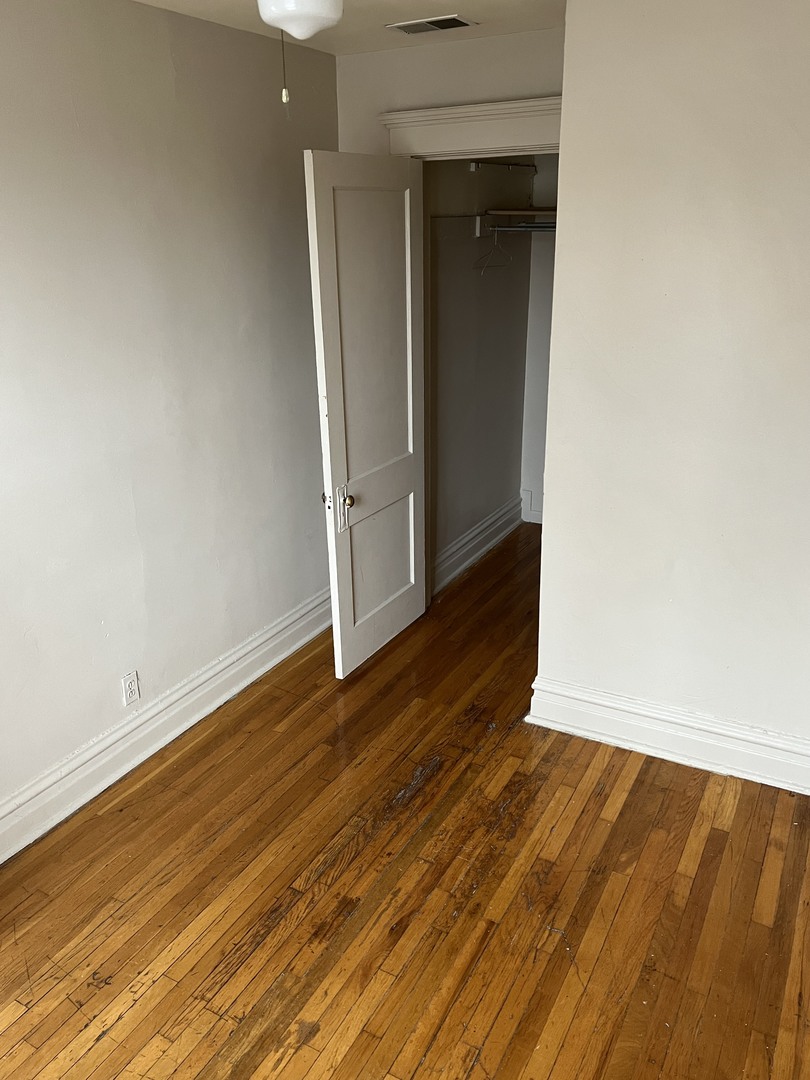 Undisclosed Address Chicago, IL 60624 - Photo 7 of 16 an empty room with wooden floor and closet