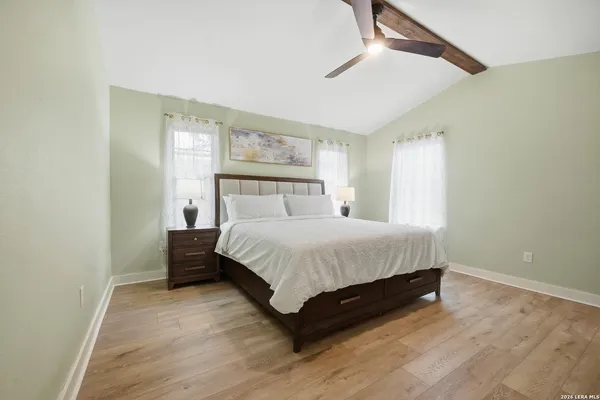 a bedroom with a bed rug and wooden floor