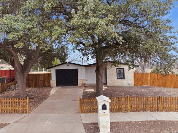 a front view of a house with a tree