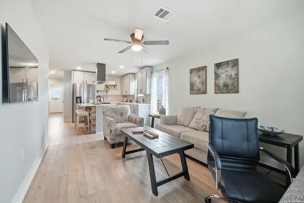 a living room with furniture and a view of kitchen