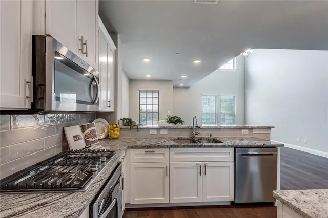 a kitchen with granite countertop a stove and a sink
