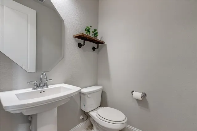 a bathroom with a sink mirror and toilet
