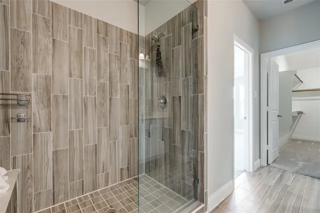 a bathroom with a shower and a glass door