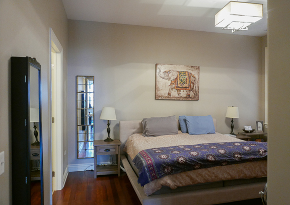 Undisclosed Address Chicago, IL 60607 - Photo 31 of 47 a bedroom with a large bed and a chandelier