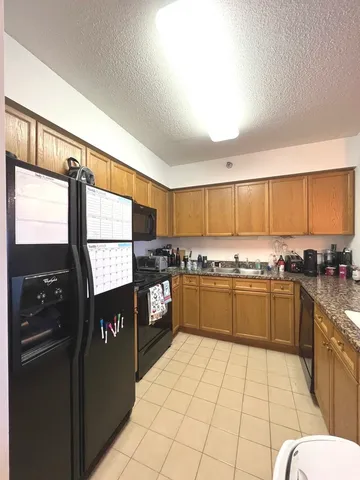 a kitchen with stainless steel appliances granite countertop a refrigerator and a stove top oven