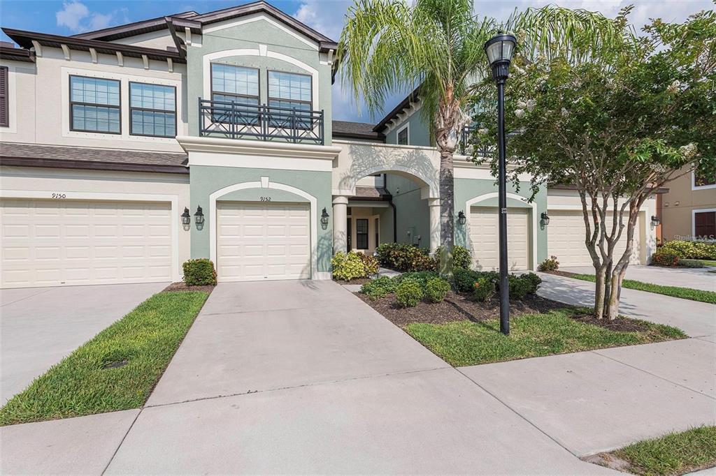 9152 Fox Sparrow Road Tampa, FL 33626 - Photo 1 of 32 a front view of a house with a garden and trees
