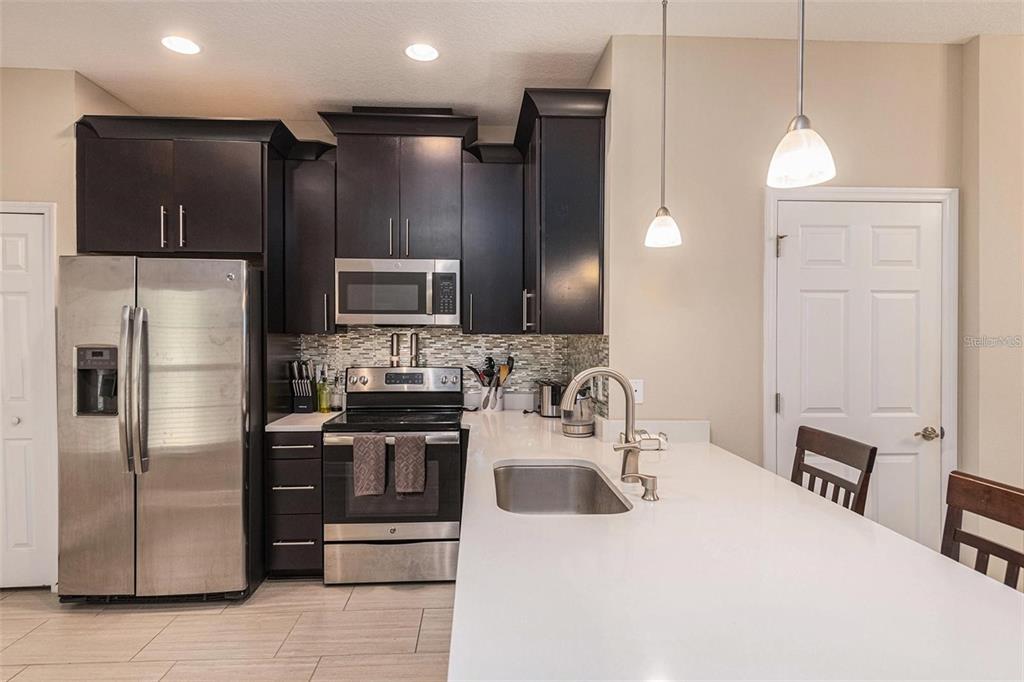 9152 Fox Sparrow Road Tampa, FL 33626 - Photo 6 of 32 a kitchen with stainless steel appliances a refrigerator a sink a stove a microwave and island