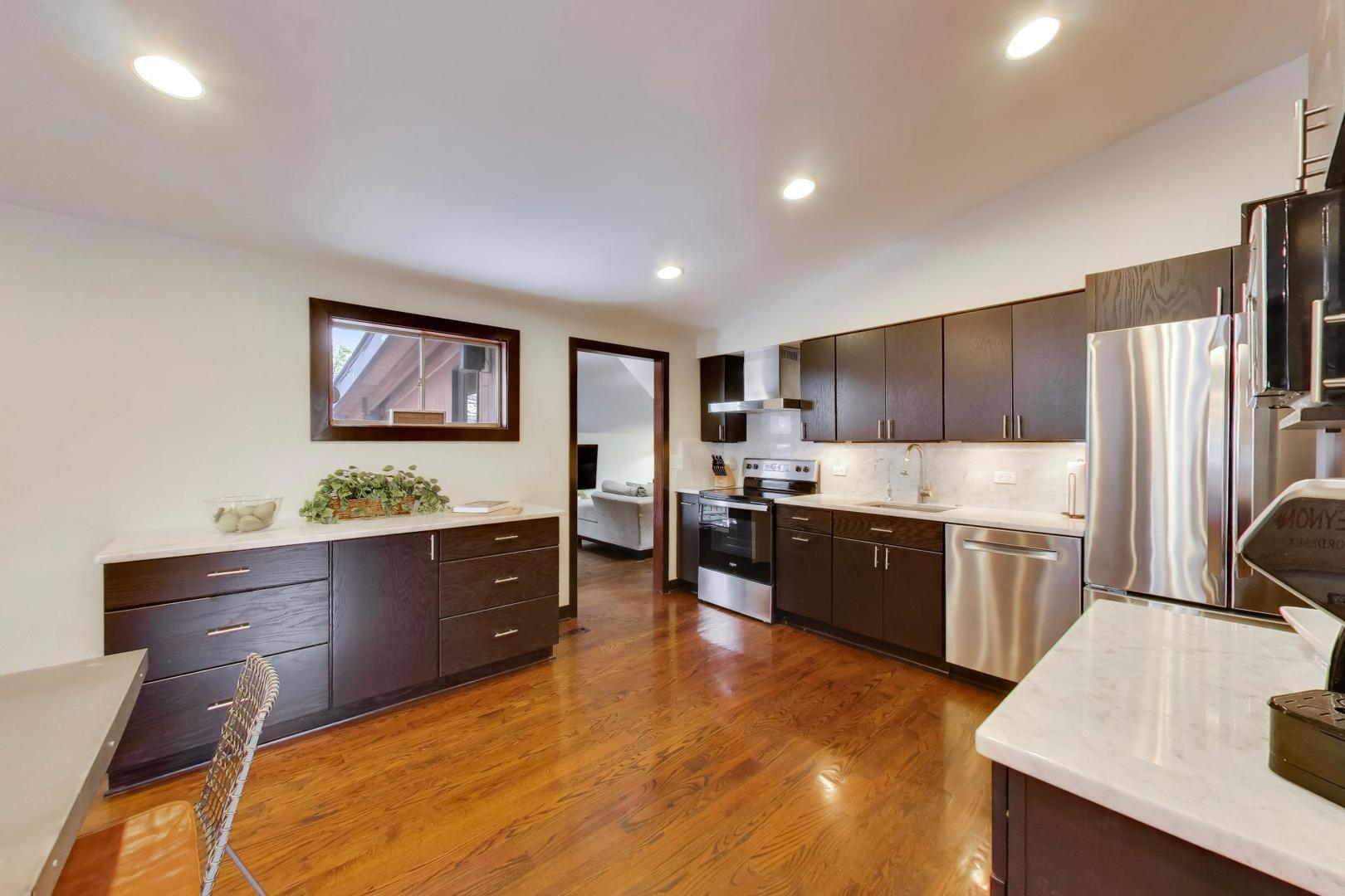 802 Lill Street Barrington, IL 60010 - Photo 3 of 27 a large kitchen with kitchen island a large counter top space a sink stainless steel appliances and cabinets