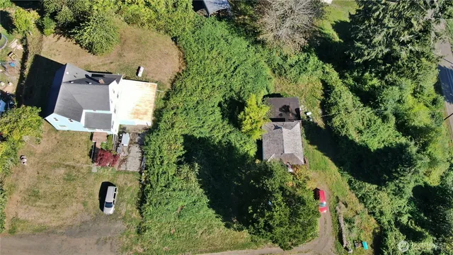 an aerial view of residential house with outdoor space and trees all around