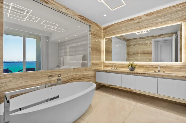 a bathroom with a granite countertop double vanity sink and a bathtub