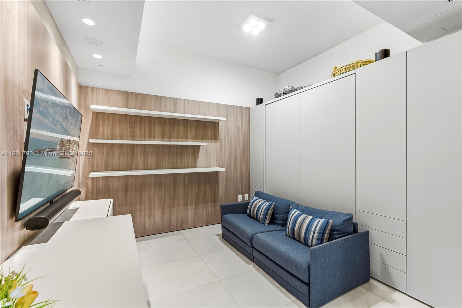 17901 Collins Avenue, Unit 1803 Sunny Isles Beach, FL 33160 - Photo 24 of 57 a living room with a couch and a flat screen tv