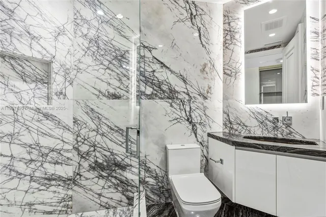 a white toilet sitting next to a shower