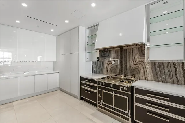 a kitchen with white cabinets and a stove top oven