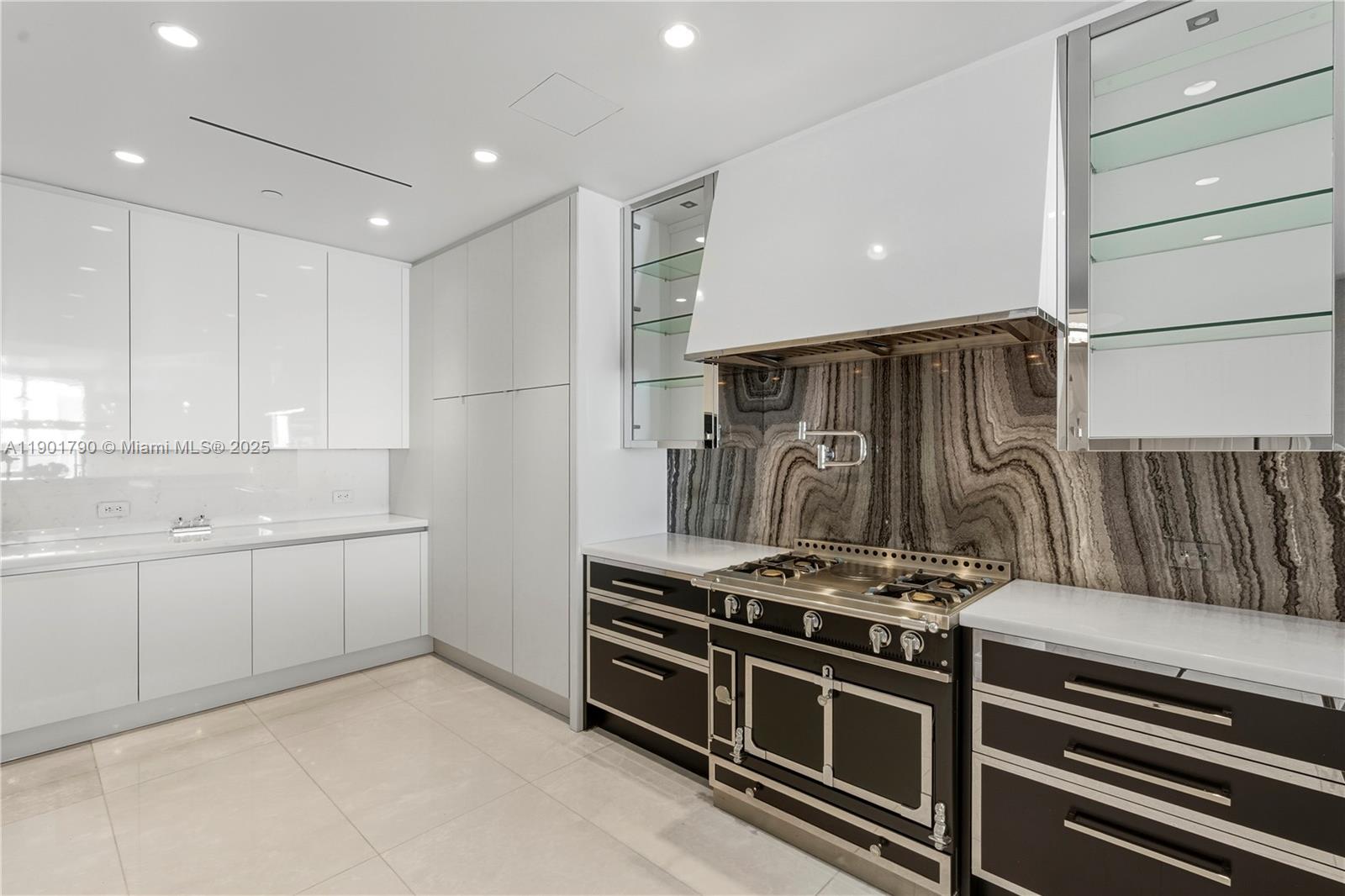 17901 Collins Avenue, Unit 1803 Sunny Isles Beach, FL 33160 - Photo 7 of 57 a kitchen with white cabinets and a stove top oven