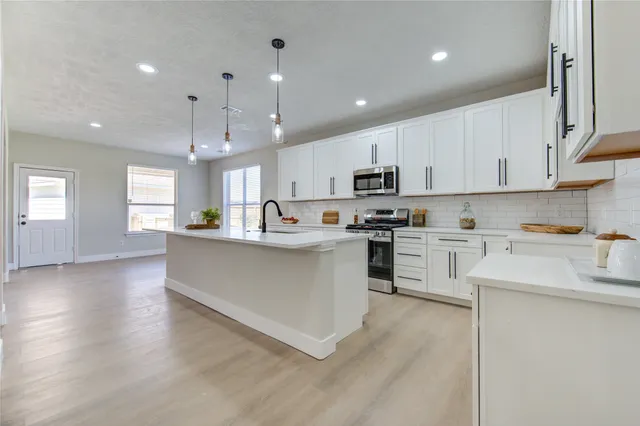 a kitchen with stainless steel appliances granite countertop a refrigerator sink and cabinets