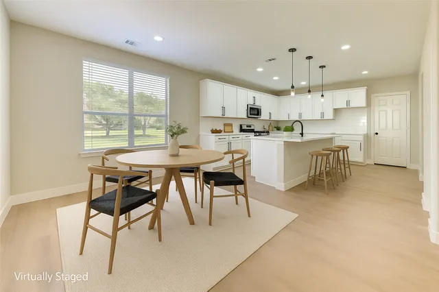 a dining room with kitchen island a table and chairs