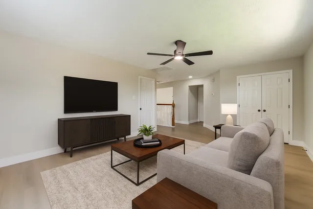 a living room with furniture a flat screen tv and a window