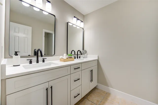 a bathroom with double sink and a mirror