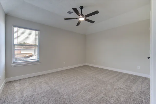 an empty room with a window and a fan