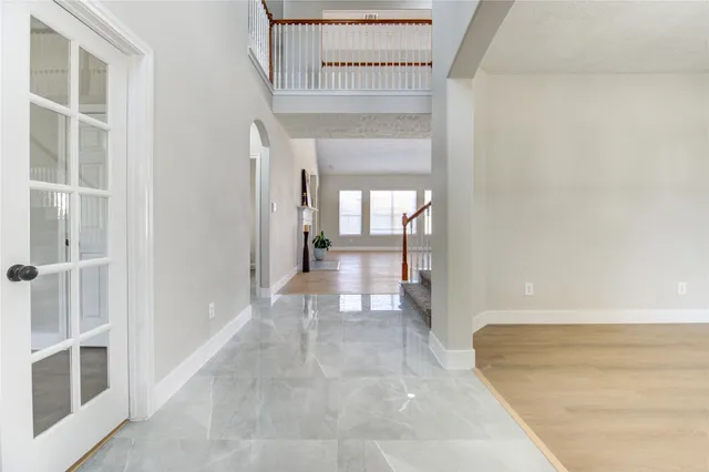 a view of a hallway with wooden floor and a living room