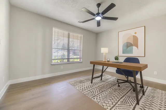 a workspace with wooden floor and a window