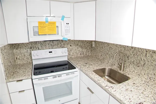 a kitchen with a sink stove and microwave