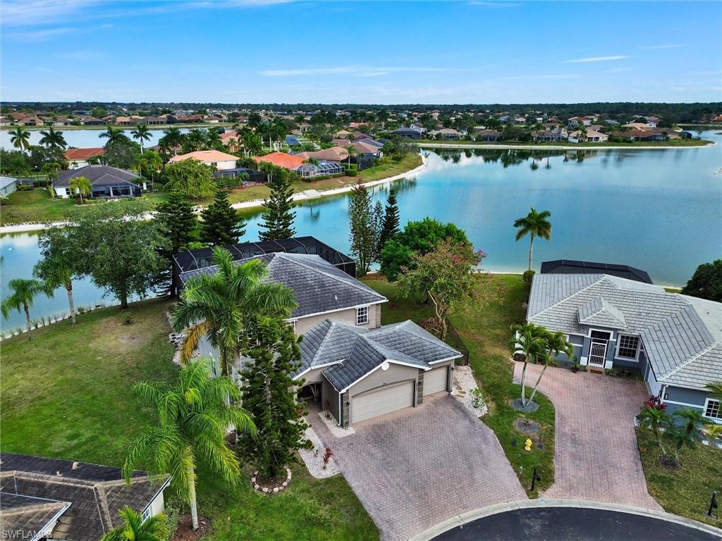 an aerial view of ocean and residential houses with outdoor space