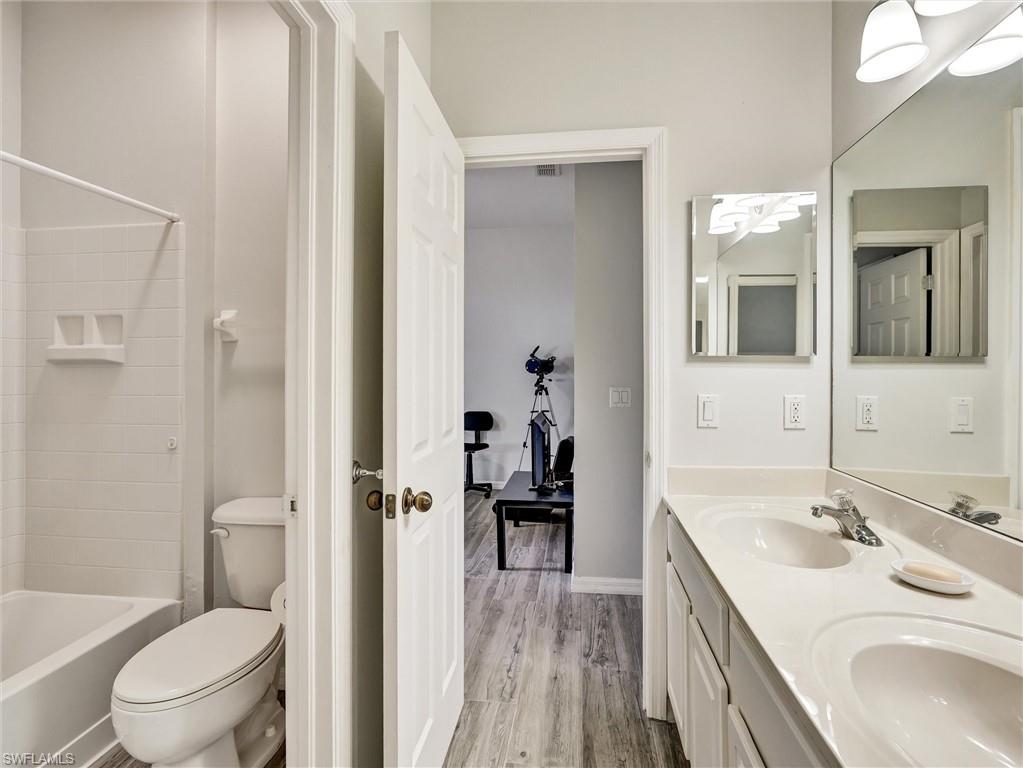 2941 Inlet Cove Lane East Naples, FL 34120 - Photo 14 of 50 a bathroom with a sink a toilet and a large mirror