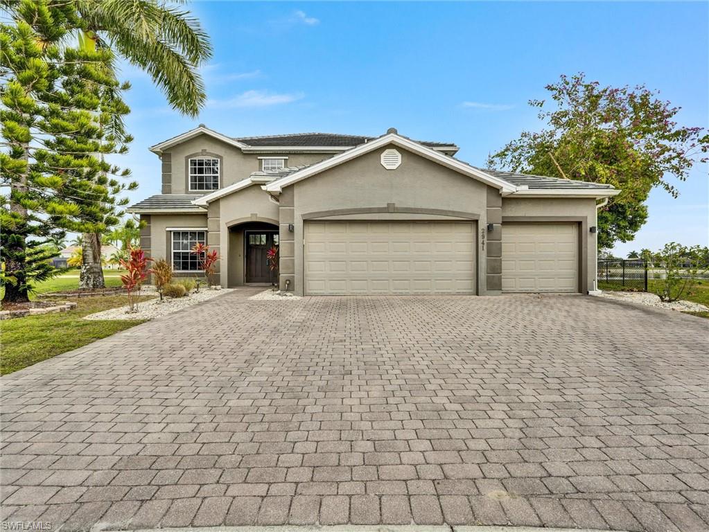 2941 Inlet Cove Lane East Naples, FL 34120 - Photo 2 of 50 a front view of a house with a yard and garage