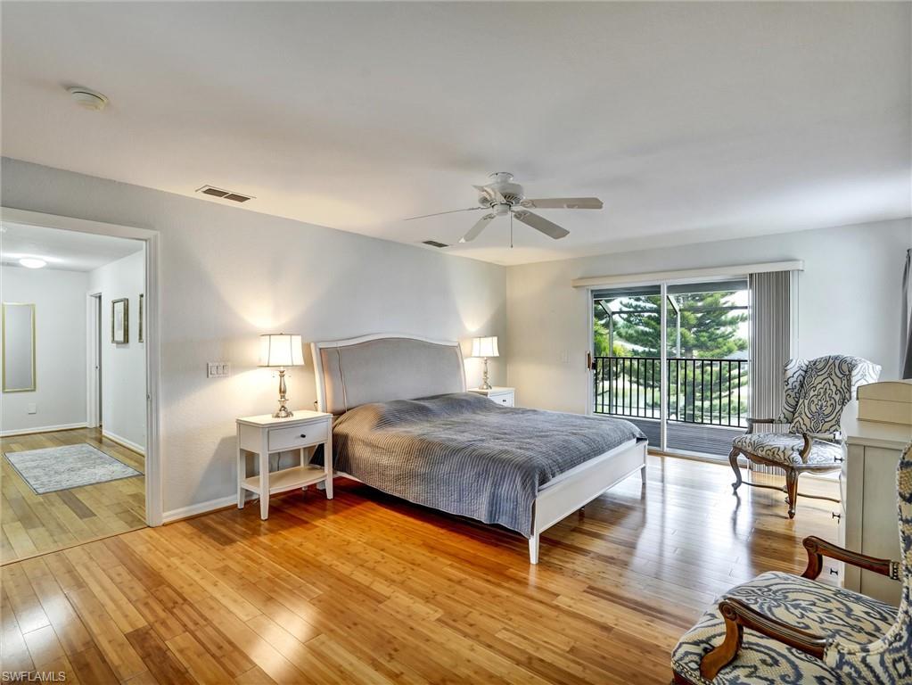 2941 Inlet Cove Lane East Naples, FL 34120 - Photo 21 of 50 a bedroom with a bed and large windows