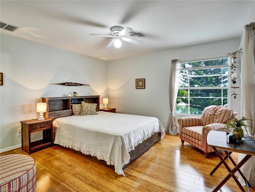 2941 Inlet Cove Lane East Naples, FL 34120 - Photo 30 of 50 a bedroom with a bed and wooden floor