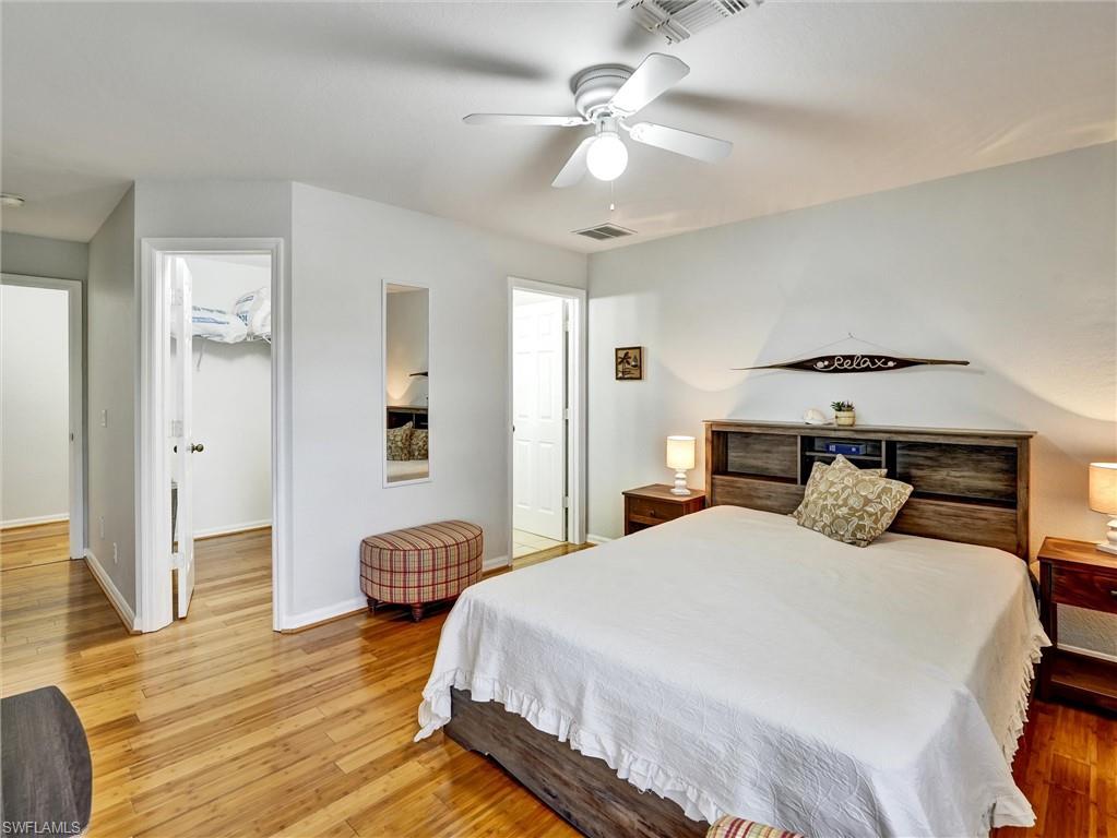 2941 Inlet Cove Lane East Naples, FL 34120 - Photo 32 of 50 a bedroom with a bed and wooden floor