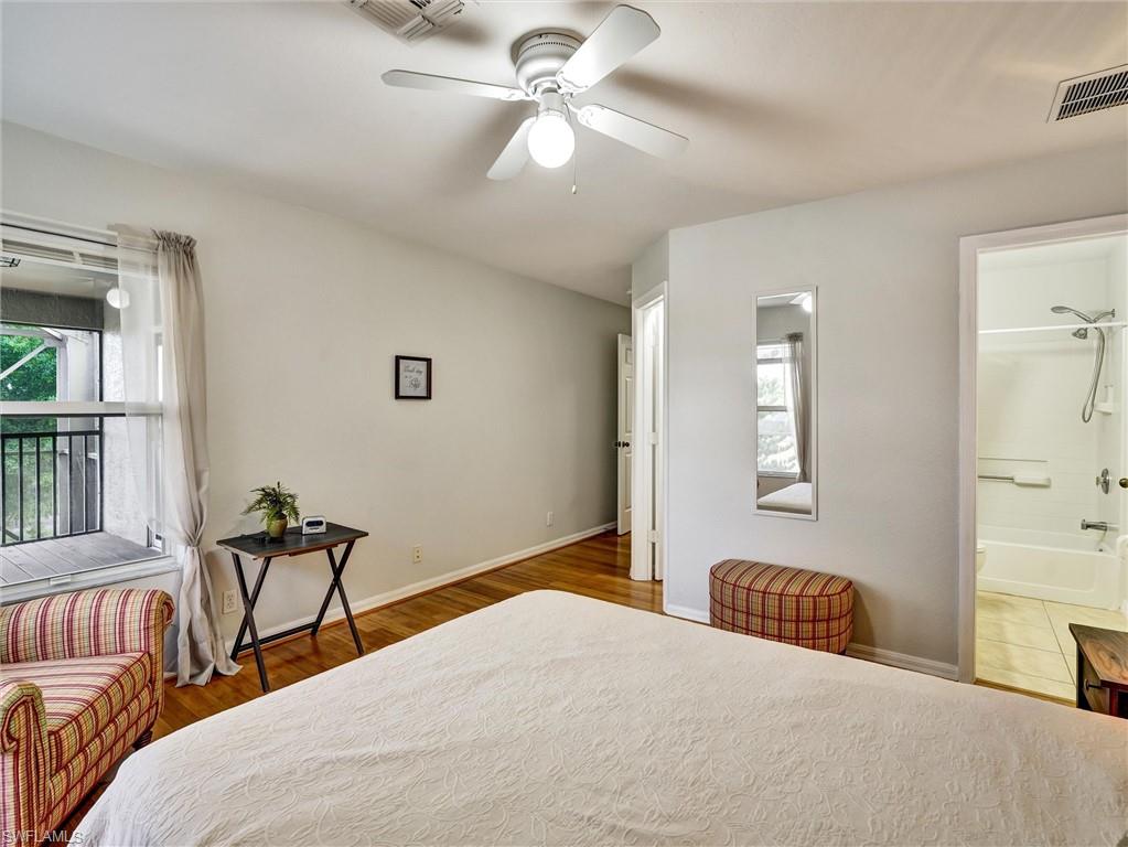 2941 Inlet Cove Lane East Naples, FL 34120 - Photo 33 of 50 a bedroom with a bed and wooden floor