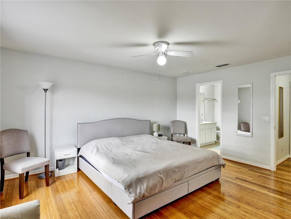 2941 Inlet Cove Lane East Naples, FL 34120 - Photo 37 of 50 a bedroom with a bed and wooden floor