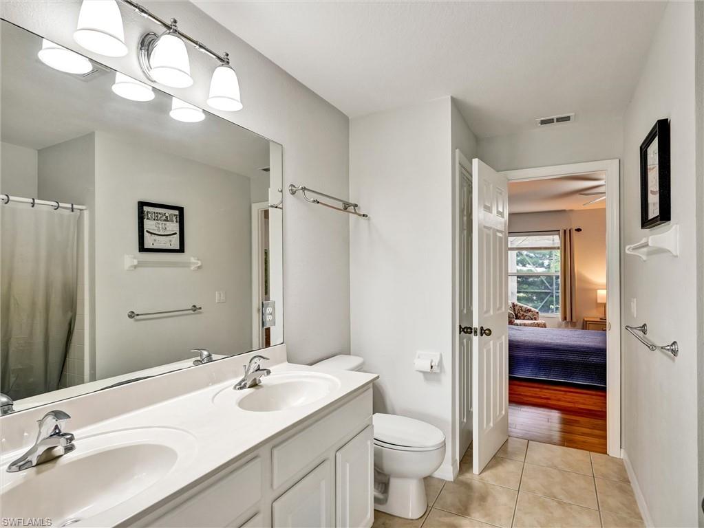 2941 Inlet Cove Lane East Naples, FL 34120 - Photo 39 of 50 a bathroom with a sink a toilet and a large mirror