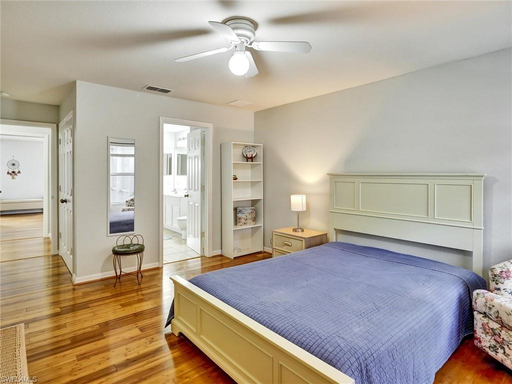2941 Inlet Cove Lane East Naples, FL 34120 - Photo 43 of 50 a spacious bedroom with a bed and wooden floor