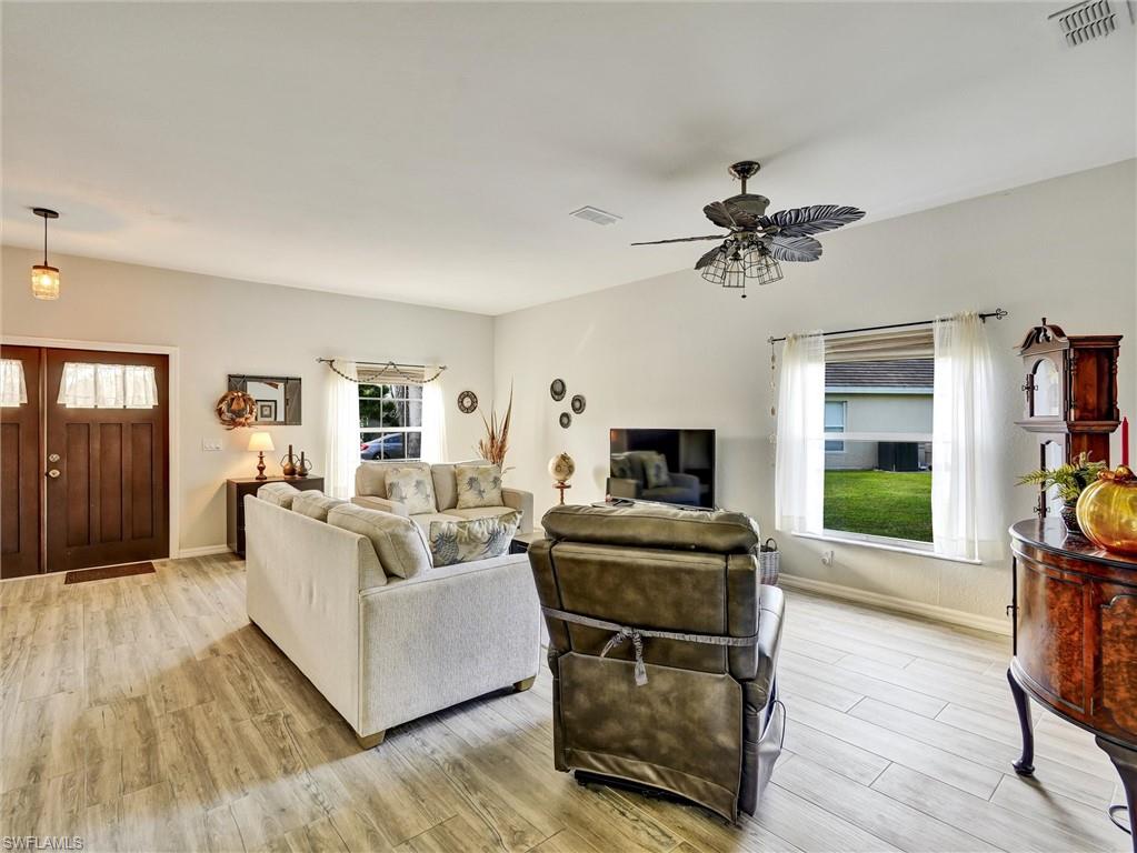 2941 Inlet Cove Lane East Naples, FL 34120 - Photo 6 of 50 a living room with furniture a flat screen tv and a fireplace