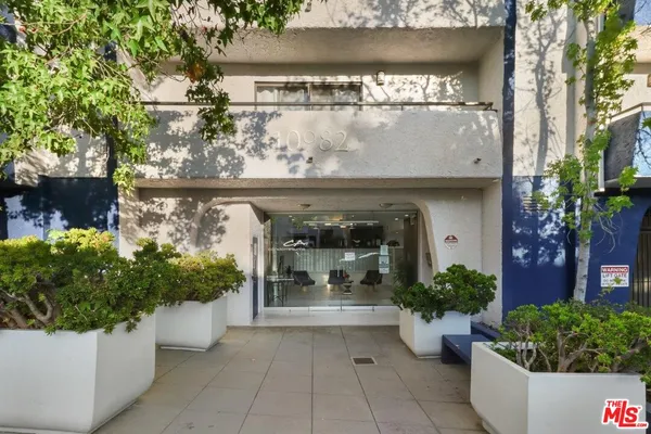 a front view of a house with potted plants