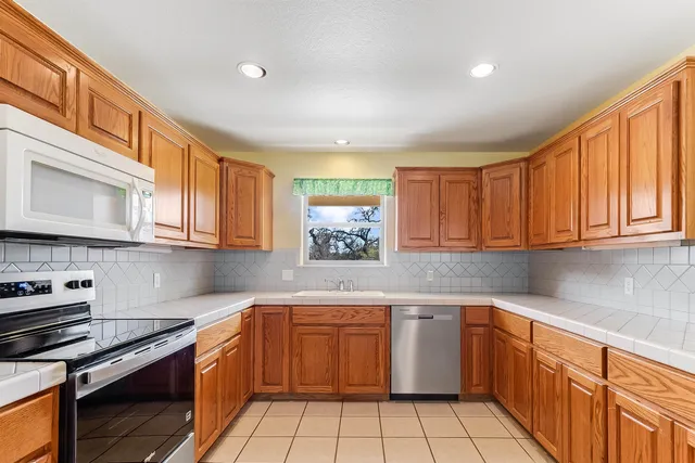 a kitchen with a sink stove top oven and cabinets
