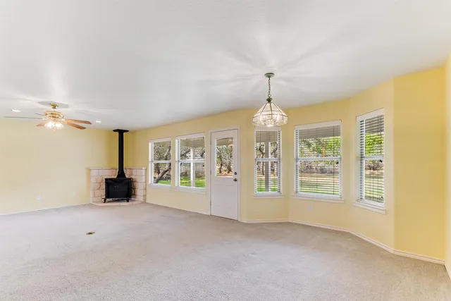 a view of an empty room with a fireplace and a window