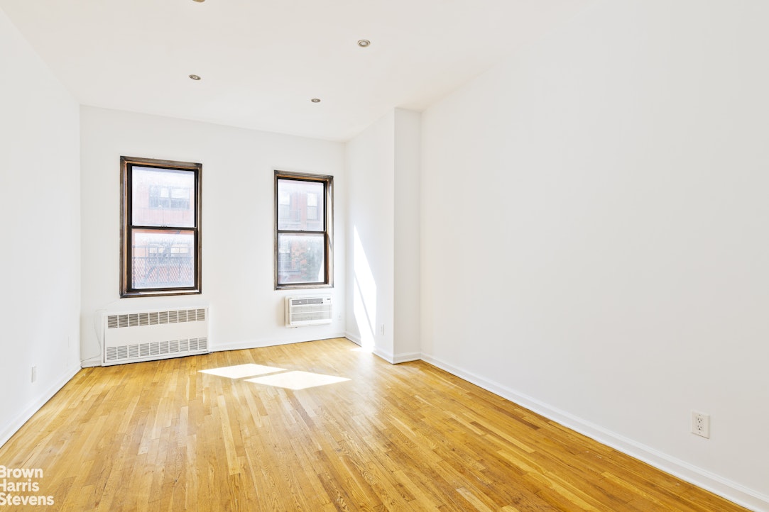 435 East 85th Street, Unit 4C Manhattan, NY 10028 - Photo 2 of 9 a view of empty room with wooden floor and fan
